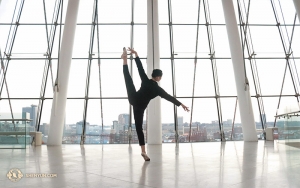 La danseuse Helen Li profite d’une après-midi de pause dans le hall du Kauffman Center for the Performing Arts à Kansas Cit, pour se détendre en exécutant avec désinvolture un páng tuǐ tǎng shēn (旁腿躺身) ou « jambe sur le coté et corps incliné. » (Photo de la danseuse Diana Teng)
