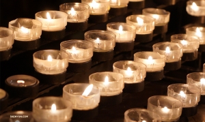 Des rang&eacute;es de bougies de pri&egrave;re illuminent la cath&eacute;drale. (Photo de Tiffany Yu)<br />